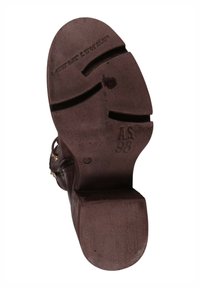 Brązowa podeszwa z teksturowanej skóry, wyposażona w rowki dla lepszej przyczepności, z tłoczonymi detalami i niewielkim obcasem.