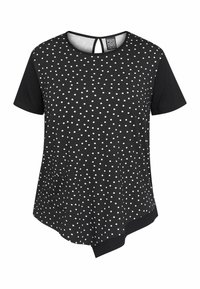T-shirt nera a maniche corte con pois bianchi, orlo asimmetrico, scollatura rotonda e un piccolo dettaglio a chiave sulla schiena con tasca.