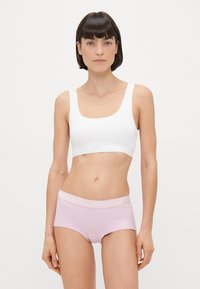 Λευκό bralette με φαρδιές τιράντες και λογότυπο στη ζώνη. Ανοιχτό μωβ boyshorts με αντίθεση στη ζώνη με το λογότυπο. Λείος ύφασμα και εφαρμοστή σχεδίαση.