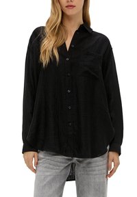 Zwarte button-up overhemd met een gestructureerde afwerking, voorzien van een voorzak en lange mouwen. Gemaakt met lichtgrijze denim.