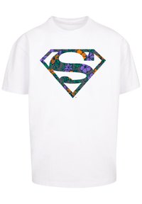 White t-shirt featuring a multicolored floral patterned Superman logo in the center. Short sleeves and a standard crew neck design.