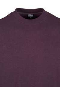 Sweat-shirt col rond violet foncé en tissu doux, taille M, avec col côtelé et étiquette de la marque Urban Classics à l'intérieur du col.