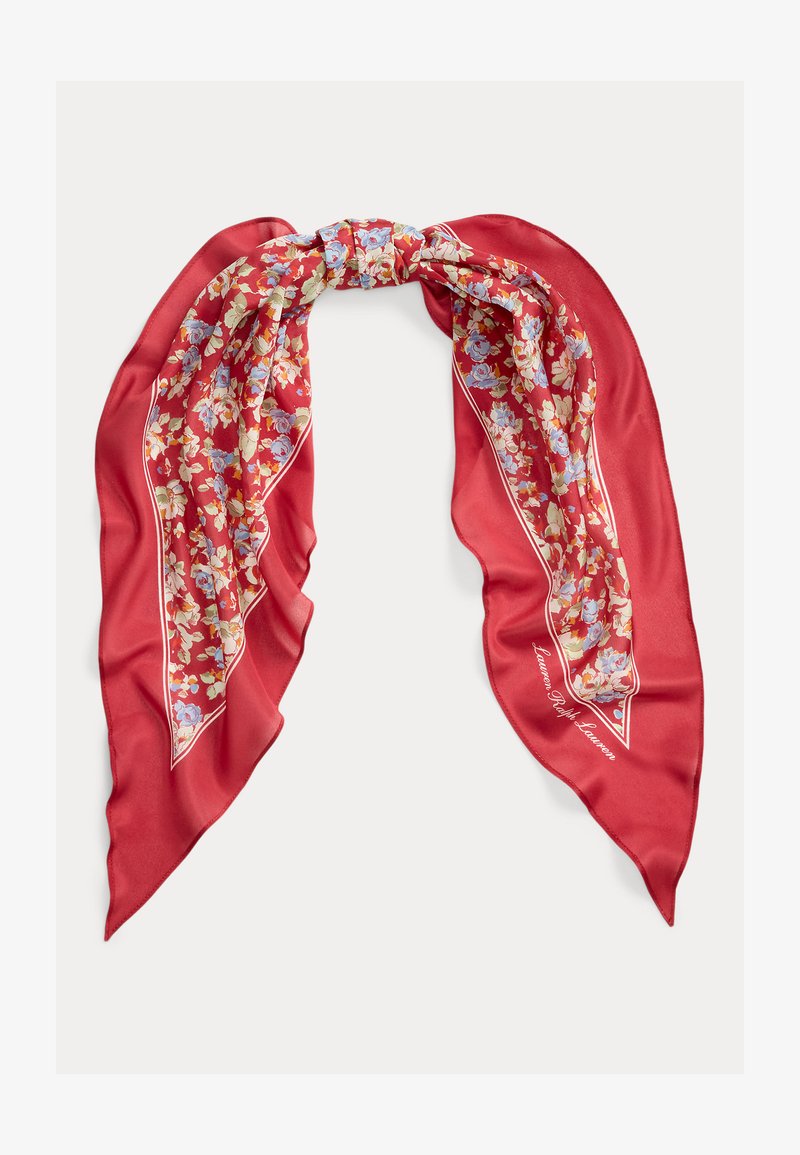 Écharpe en soie rouge avec imprimé floral en bleu, blanc et jaune, nouée lâchement avec des extrémités pointues.