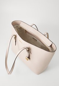 Beige leather tote bag with an open top, smooth interior, gold hardware accents, dual shoulder straps, and subtle textured surface.