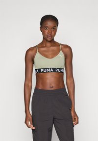 Svijetlo maslinasto zeleni sportski grudnjak s podesivim trakama i crnim pojasom s bijelim logotipom "PUMA". Jednostavan, prilagođen dizajn, glatka tekstura.
