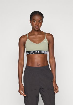 Light olive green sports bra with adjustable straps and a black band featuring white "PUMA" logo. Simple, fitted design, smooth texture.