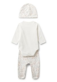 Bílý kojenecký overal s dlouhým rukávem, doplněný kalhotami s motivem králíčka a odpovídající čepičkou, vše rozložené na bílé pozadí.