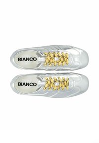 Baskets argentées avec une finition brillante, dotées de lacets à motifs jaunes et noirs, et d'un intérieur blanc avec le logo "BIANCO".