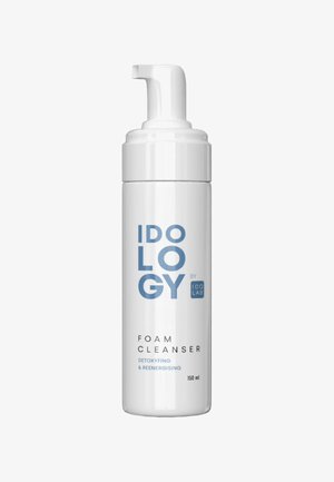 Biała cylindryczna butelka z pompką, oznaczona napisem "IDOLOGY FOAM CLEANSER" w niebieskim kolorze. Pojemność 150 ml, zaprojektowana do detoksykacji i rewitalizacji.