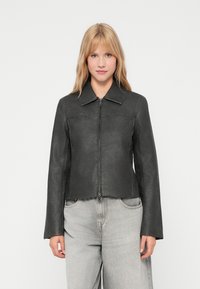Veste en cuir noir avec un col, fermeture éclair à l'avant et manches longues. Présente un design court et une texture lisse.