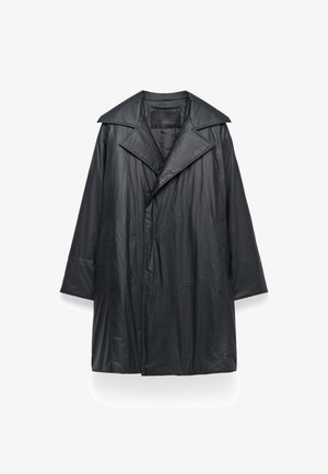 Zwarte, lichte, lange jas van gekreukt materiaal; heeft een brede kraag, een oversized ontwerp en zijzakken. Eenvoudige sluiting aan de voorkant.
