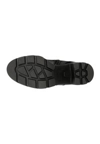 Black rubber shoe sole with a tread pattern featuring deep grooves and hexagonal accents. Sturdy design for traction and durability.