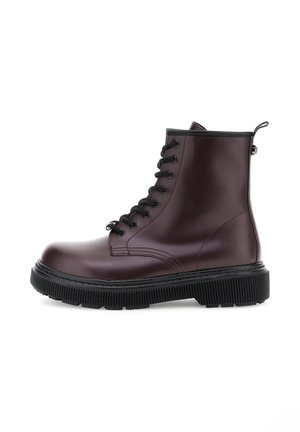 Burgundy leather ankle boot with black laces, rubber sole, and a textured tread. Features a side zipper and stitching details for structure.