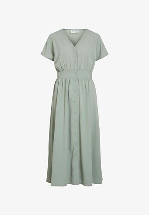 Zelena obleka do kolen iz mehkega blaga, ki ima V-izrez, kratke lepršave rokave, zapenjanje na gumbe spredaj in zategnjen pas.