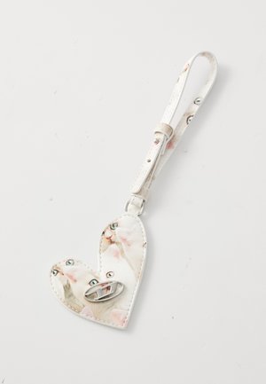 Heart-shaped white faux leather keychain featuring a printed design of cats with blue eyes. Includes a silver hardware clasp.