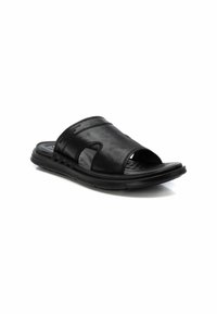 Sandali in pelle nera con design aperto, fascia ampia e suola testurizzata con una base flessibile.