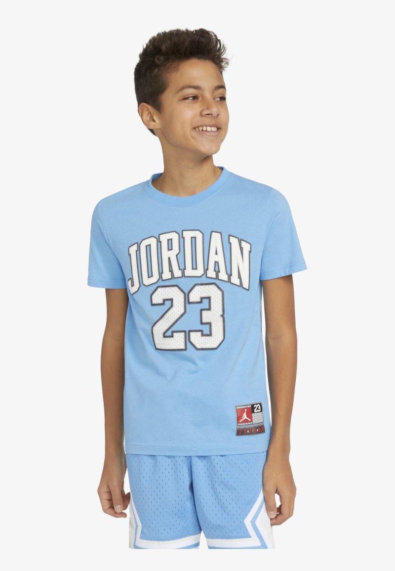 Světle modré bavlněné tričko s nápisem "JORDAN" a číslem "23" v bílé a černé, spárované s odpovídajícími síťovanými šortkami s bílým lemem a akcenty.