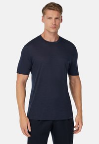 Mörkblå t-shirt med kort ärm, tillverkad av mjukt och lätt material, med rund halsutskärning och en subtil texturerad yta.