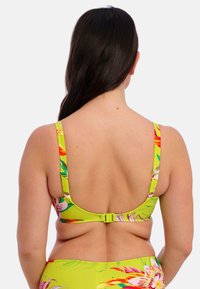 Geel bloemen bikinitop met brede banden en een haaksluiting aan de achterkant, met levendige tropische patronen in roze en groen. Gladde textuur.