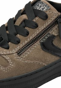 Sneaker din suede maro cu sireturi negre, fermoar lateral, detaliu din piele neagră și talpă din cauciuc texturat negru.