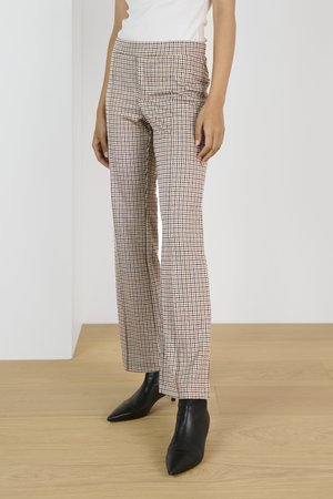 Plaid tapered pants in beige, brown, and black tones; features a flat front, side pockets, and a smooth fabric texture. Paired with pointed black boots.