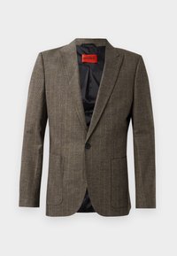 Brun rutigt blazer i texturerad tyg, med två framfickor, notchade slag, och en enda svart knappstängning. Röd inneretikett.