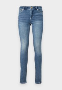 Jeans ajustados en denim azul medio, con una textura suave, cinco bolsillos, cierre de cremallera y dobladillos partidos en los tobillos.