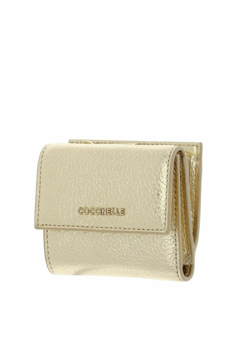 Petit porte-monnaie en cuir métallisé doré avec une fermeture à rabat et le logo de la marque "Coccinelle" en lettres dorées sur le devant.