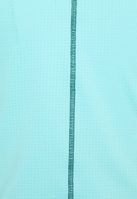 Vaaleansininen kangas, jossa on tekstuuri ja pystysuora tikkauksella tumma petrooli keskellä. Sileä pinta, hengittävä materiaali.