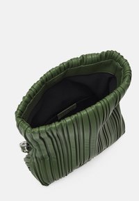 Clutch de cuero verde con diseño plisado, forro interior negro y detalles en hardware plateado. Forma rectangular con un borde gathered.