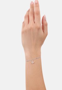 Braccialetto con charm a forma di ancora in argento, dotato di una delicata catena che presenta piccoli accenti rotondi. La catena è elegante e presenta un design nautico.