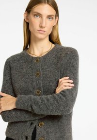 Cardigan grigio in maglia con scollatura a girocollo, maniche lunghe e cinque grandi bottoni rotondi. Tessuto morbido con polsini e orlo a costine.