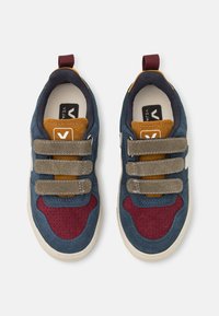 Blaue Wildledersneaker mit kastanienbraunen und braunen Akzenten, ausgestattet mit drei strukturierten Klettverschlüssen und einer weißen Gummisohle.