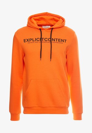 Pomarańczowa bluza z kapturem, z czarnymi sznurkami, przednia kieszeń kangurza i wyraźny napis "EKSPLICYTNA TREŚĆ" na klatce piersiowej. Miękka tekstura materiału.