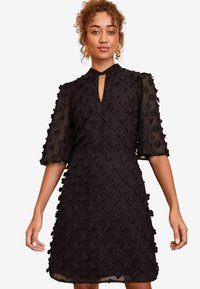 Rochie neagră cu un model floral texturat, decolteu în formă de cheie și mâneci semi-transparente, având un corset ajustat și fustă lejeră.