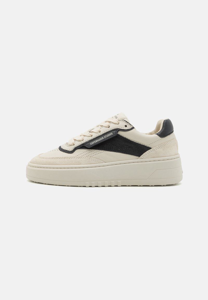 B baskets en cuir beige avec des accents en daim noir, une tige texturée, des détails perforés et une semelle épaisse et chunky pour une hauteur supplémentaire.