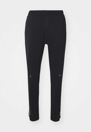 Black athletic pants with an elastic waistband, tapered design, fine stitching, and reflective accents on the sides and hems.