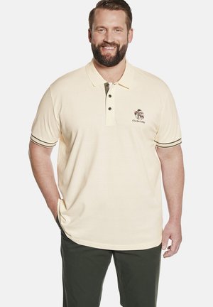 Beige Poloshirt mit dunklen Akzenten, zwei-Knopf-Kragen und einem Logo auf der Brust. Hergestellt aus glattem Stoff. Kurze Ärmel mit gestreiften Säumen.