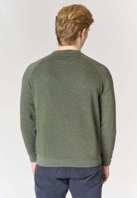 Felpa verde con maniche lunghe e scollo rotondo, caratterizzata da un tessuto testurizzato e polsini e orlo a coste. La vista posteriore non mostra grafiche.