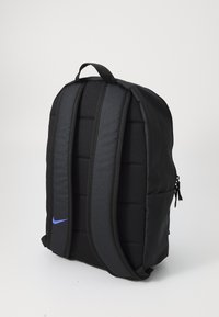 Zwarte rugzak met gevoerde schouderbanden, een gladde textuur en een blauw Nike-logo. Kenmerkt zich door een minimalistisch ontwerp en een ritscompartiment.