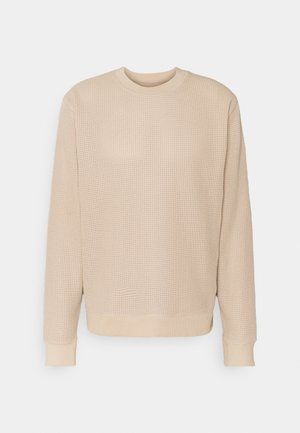 Beige gebreide trui met een gestructureerd patroon, ronde halslijn en geribbelde manchetten en zoom. Eenvoudig, comfortabele pasvorm.