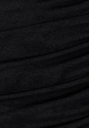 Black denim fabric with a textured, ribbed surface, showcasing diagonal creases and a smooth sheen.
