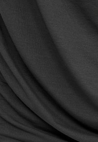 Schwarzer Stoff mit einer glatten, leicht strukturierten Oberfläche, die sanfte Falten und Drapierungen zeigt und seine leichte und flexible Beschaffenheit betont.