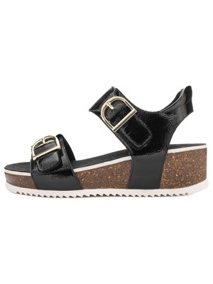 Sort kilehæl sandal i laklæder med to spænder i guld, korksål og hvid rillede ydersål, vist i sideprofil.