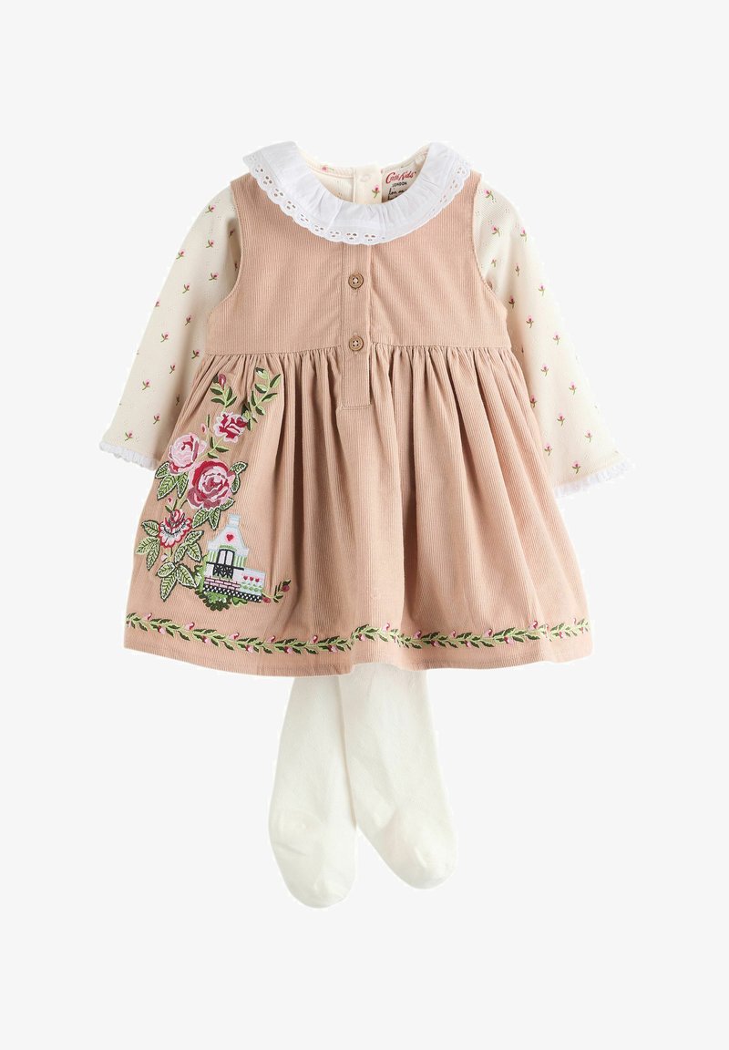 Roze ribfluwelen babyjurkje met bloemrijke borduursels over een crème lange mouwen top met kleine bloemen en witte maillots.