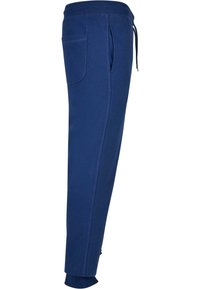 Pantaloni de trening bleumarin cu talie elastică, șnur, buzunare laterale și tivuri ajustate la glezne. Fabricat din țesătură moale și elastică.