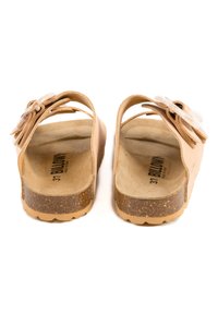 Sandales ouvertes beige avec une semelle en liège, des sangles réglables et un accent en nœud décoratif. Tige douce semblable au daim avec une semelle plate.