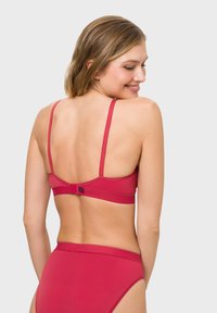 Pink bra with adjustable straps and a hook closure, paired with matching high-waisted bikini bottom, smooth texture, simple design.