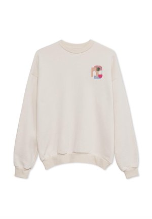 Sweatshirt couleur crème avec une coupe décontractée, des poignets côtelés et un petit graphique coloré représentant un palmier et des formes abstraites sur la poitrine.