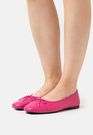 Ballerines en cuir rose avec un bout arrondi, ornées d'un nœud décoratif, avec une texture lisse et une fine semelle noire.